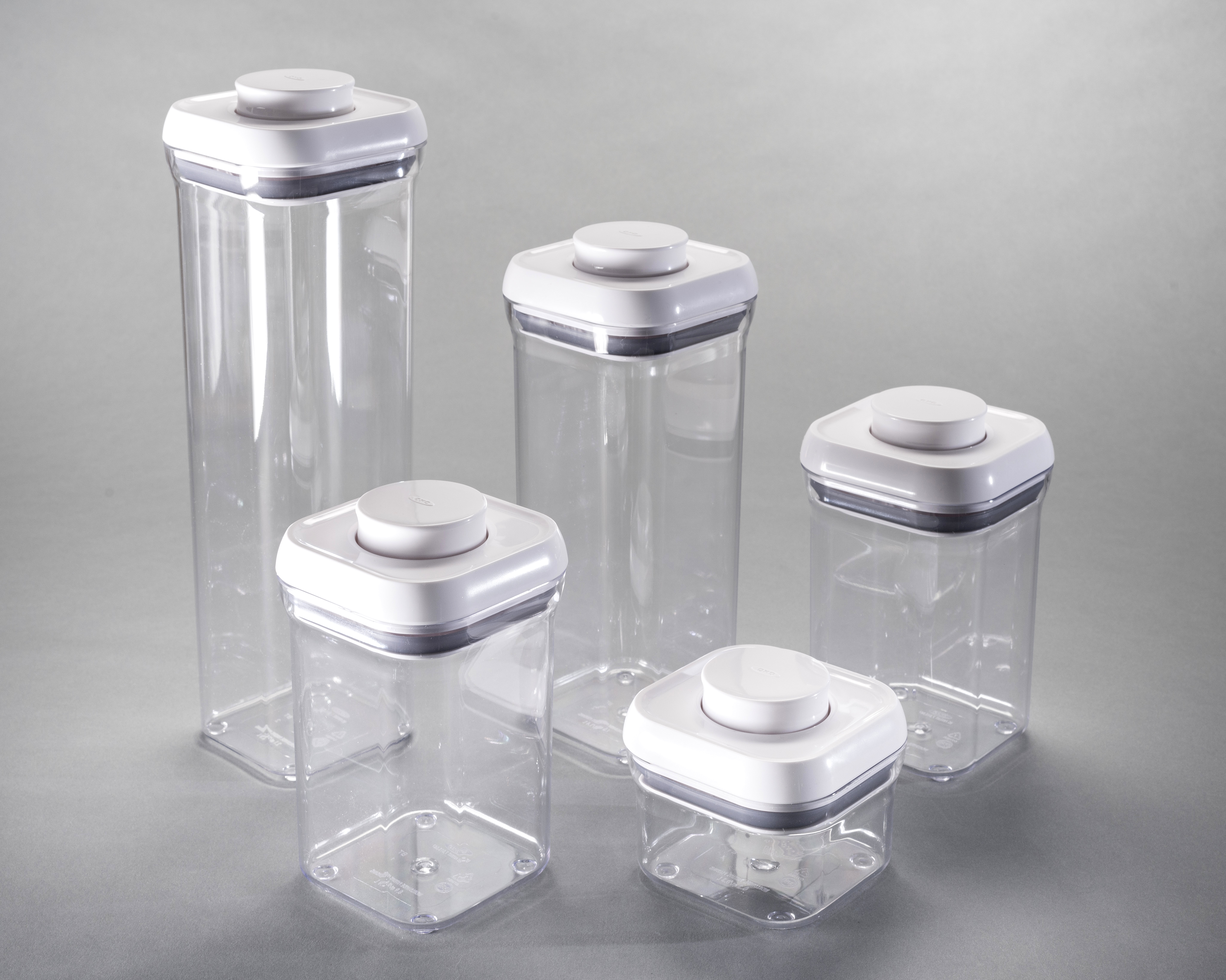 Set of rectangular, stackable, clear plastic containers with white lids.
