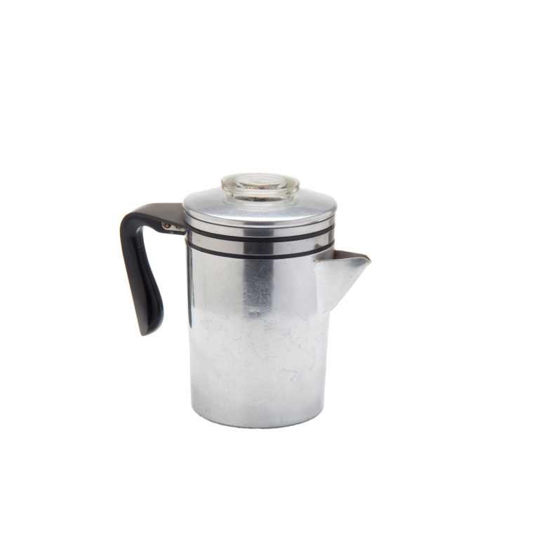 An aluminum coffeemaker. Its basic form is a cylinder with a triangular spout. A large black open handle is connected near the top. The lid has a glass disc on top for viewing the percolating coffee