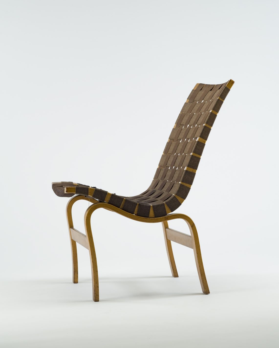Tall-backed chair with curving bentwood frame and seat and back made of woven strips of brown jute.