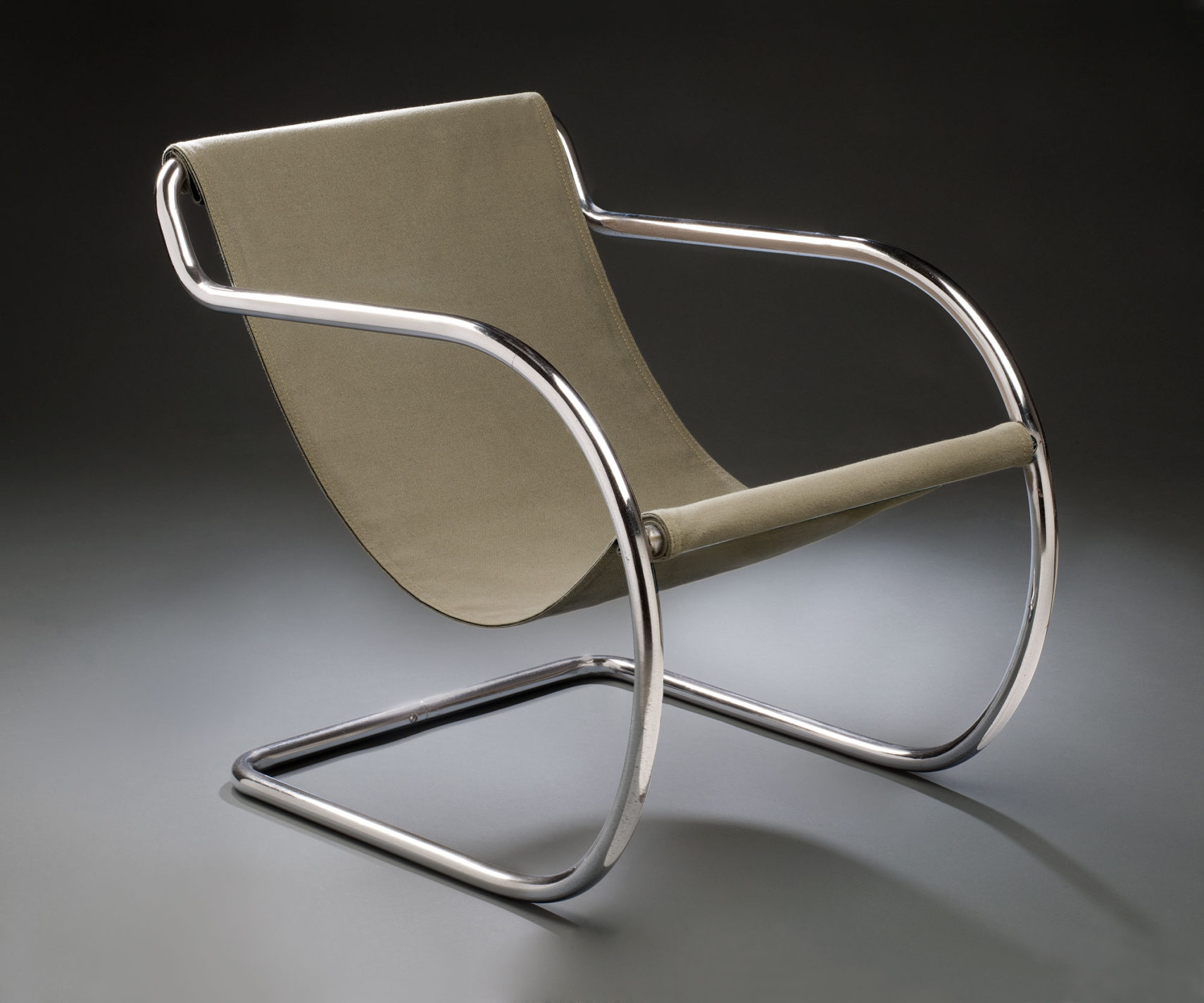 Armchair with a frame made of a continuous piece of curving tubular steel and the seat and back made from a piece of fabric suspended between two bars.