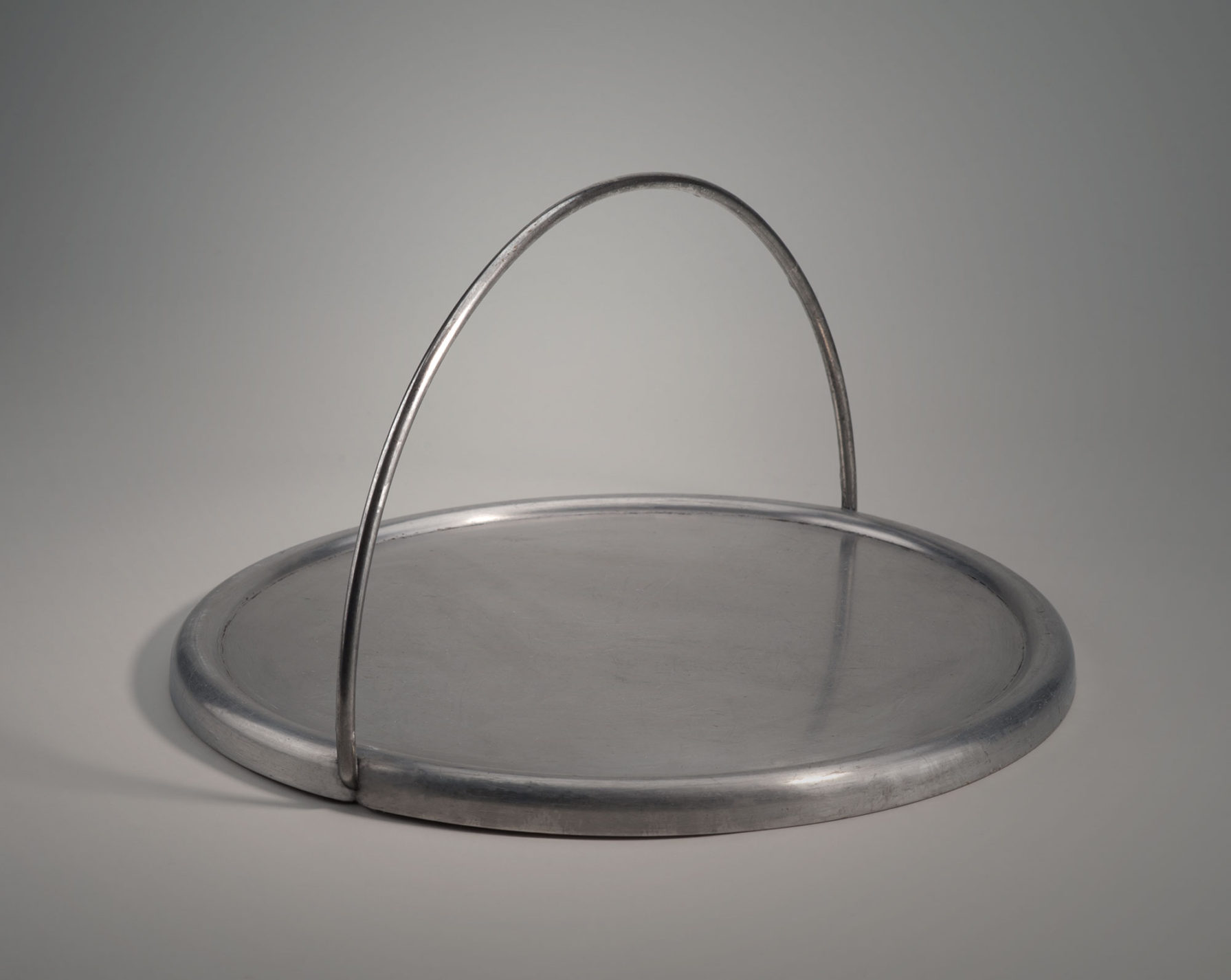Crêpière ronde en aluminium avec poignée d’aluminium en demi-cercle repliable vers l’extérieur.