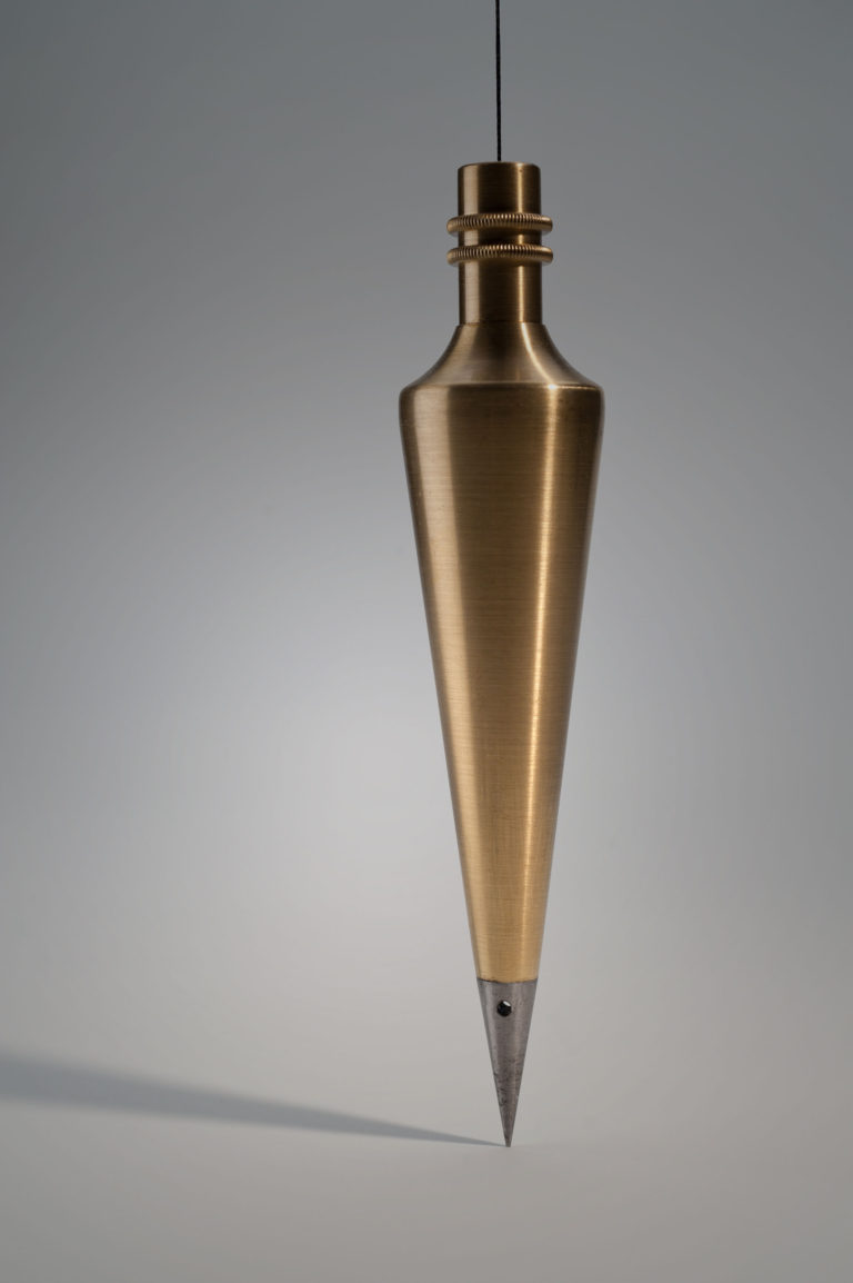 Plumb bob. Conical brass weight with a sharply pointed steel tip.