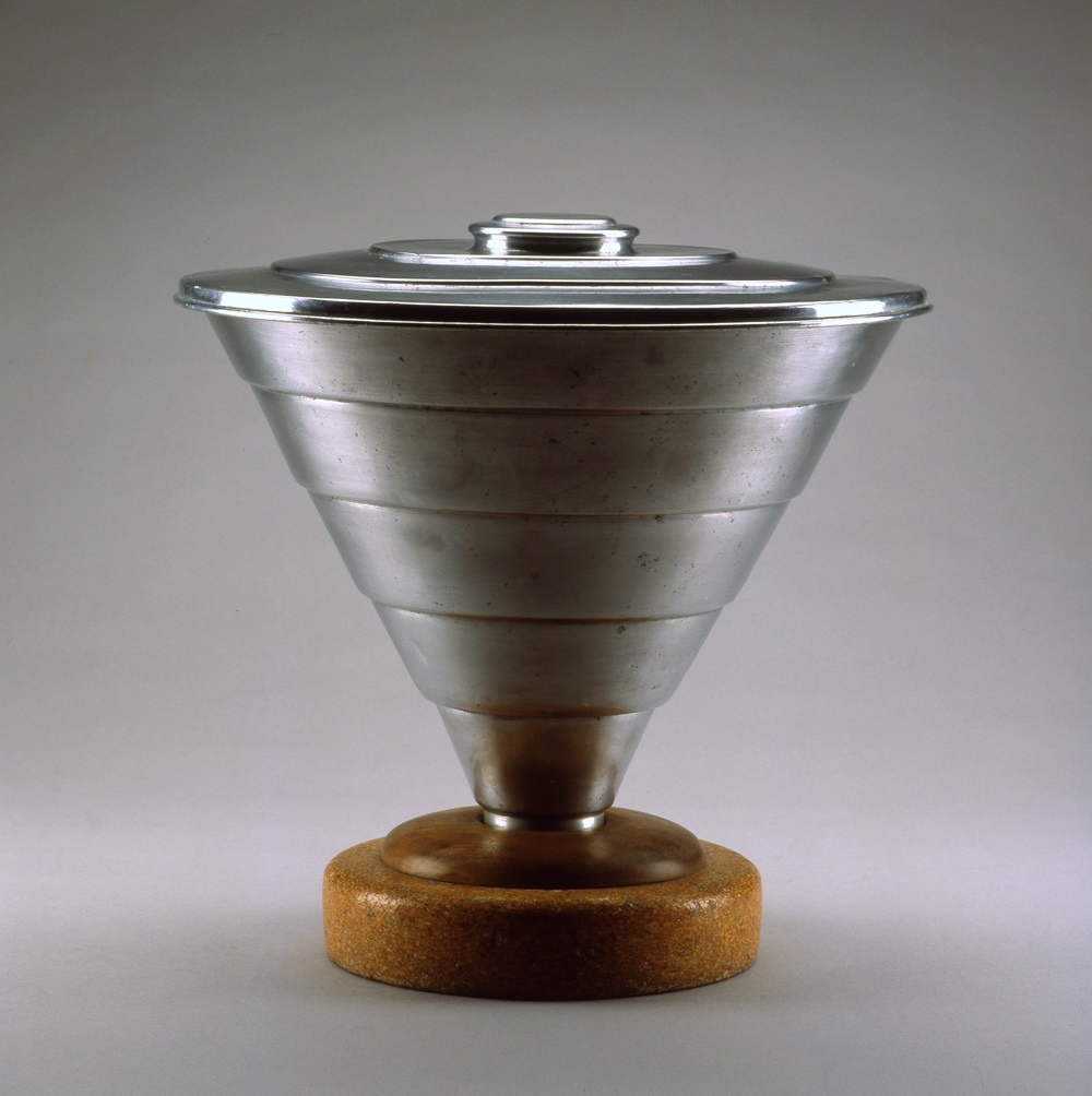 Conical metal pail with circular metal lid and tapering down to a circular cork base.