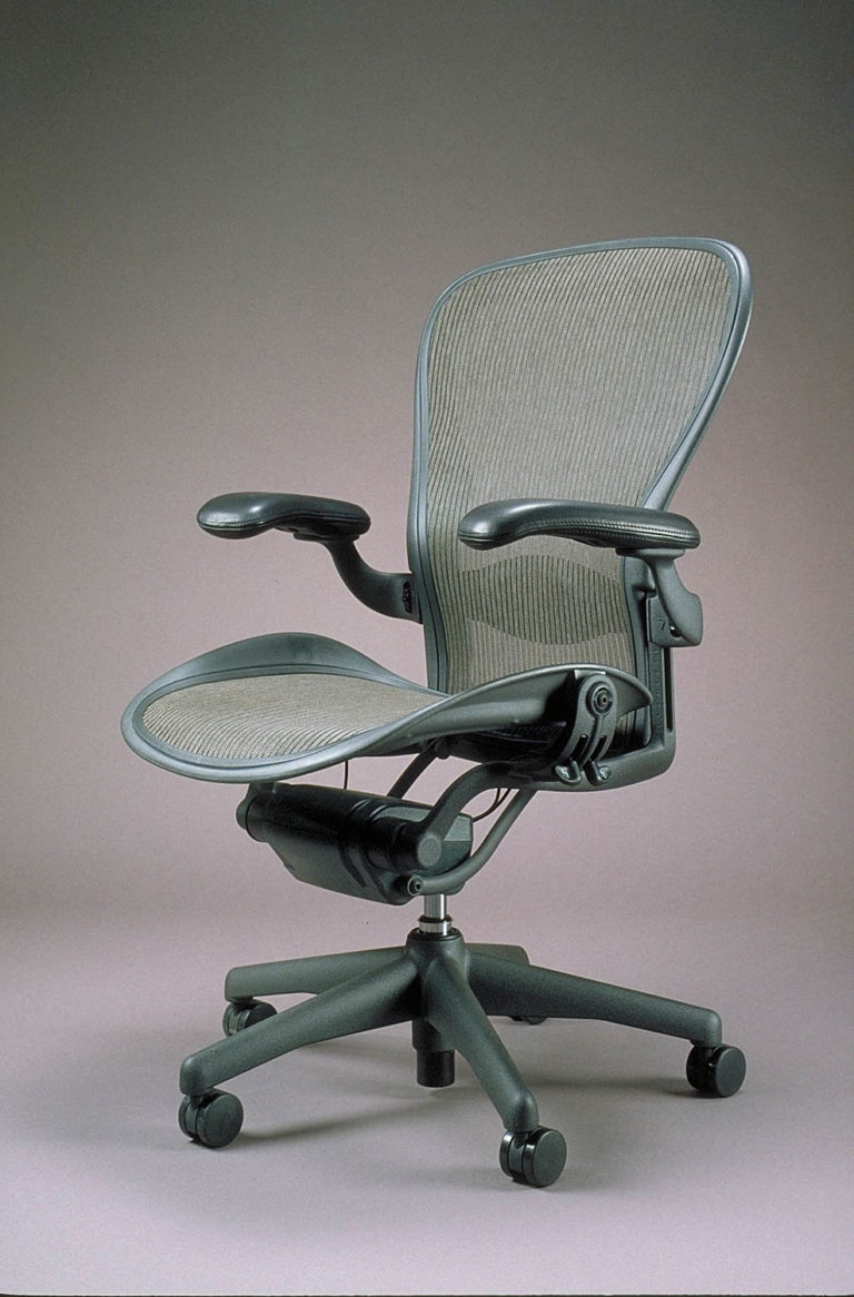 Chaise de bureau pivotante sur roulettes avec composants mécaniques visibles.