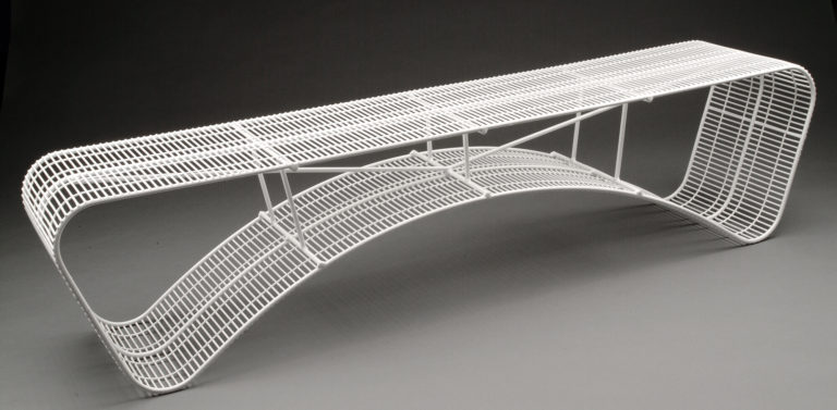 White bench made of crisscrossing wires of different thicknesses. The bench is flat on top and curved underneath.