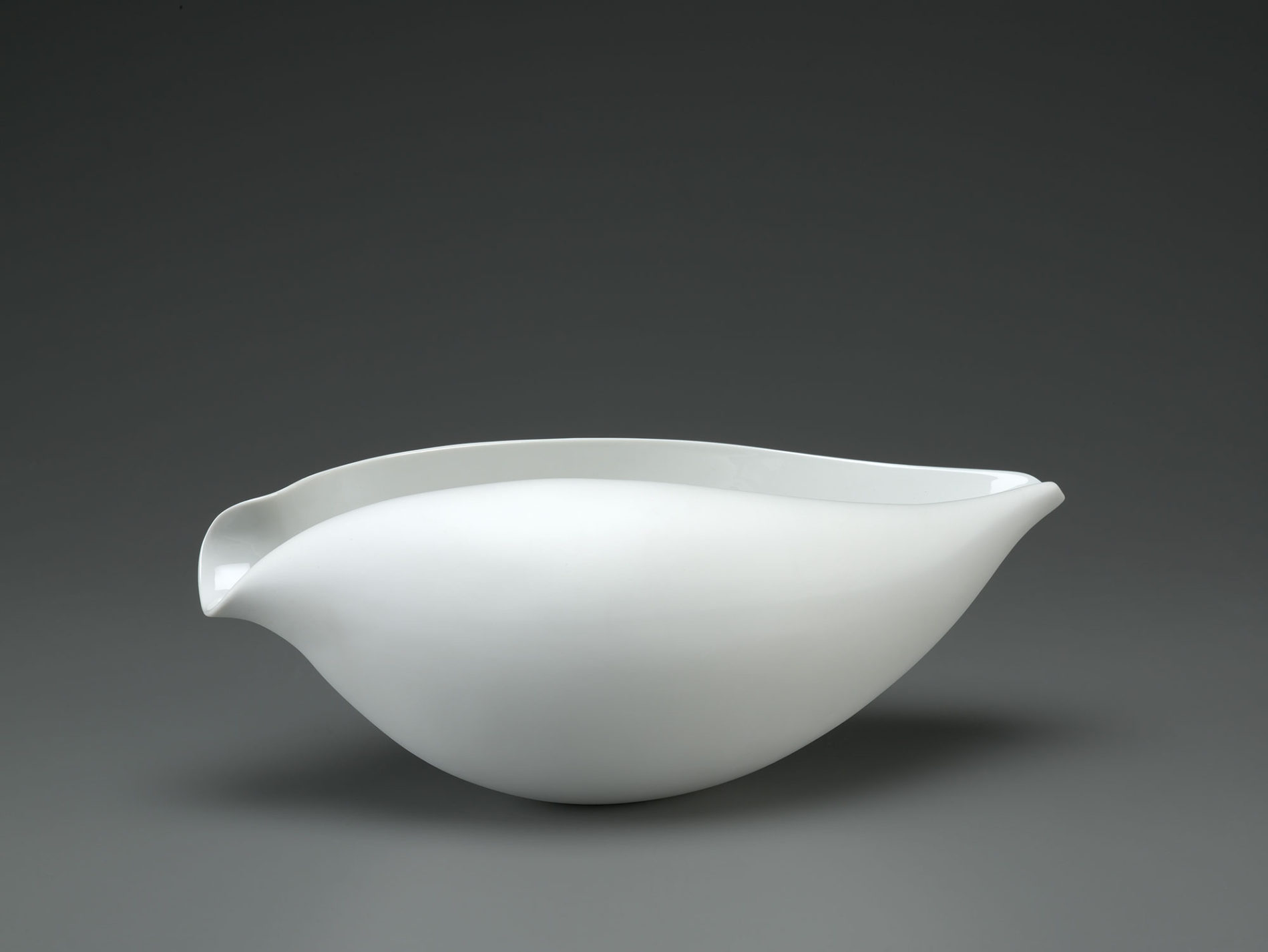 Oblong bowl that curls inward at the top, resembling a seashell.