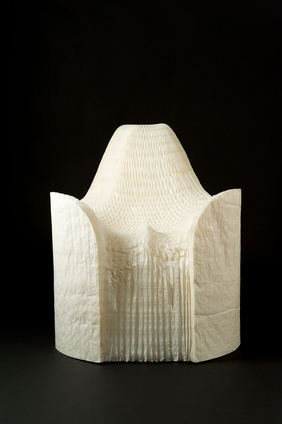 Fauteuil composé de milliers de feuilles de papier blanc plissées.