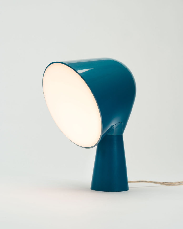 Lampe de table en plastique bleu à base mince légèrement conique; partie supérieure plus large de forme conique et disque translucide recouvrant la source lumineuse.