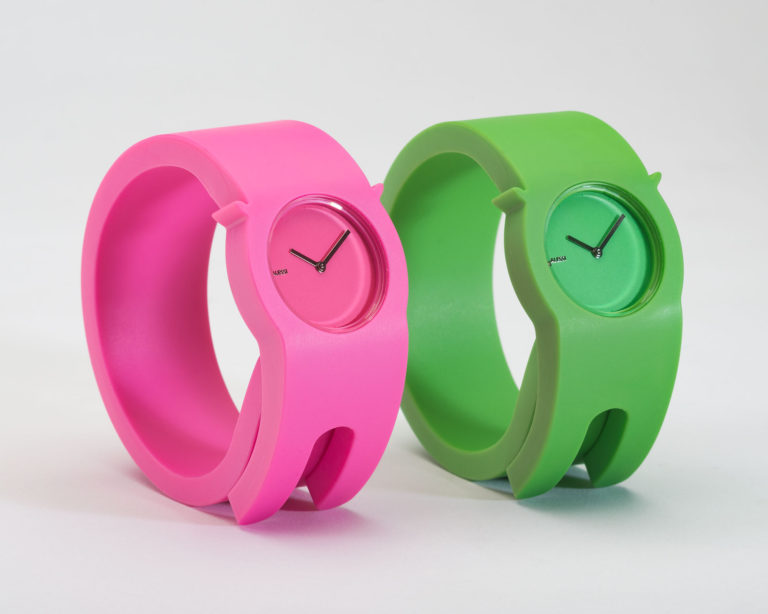 Deux montres de plastique à enrouler au poignet, une rose et une verte, avec cadran assorti et aiguilles métalliques.