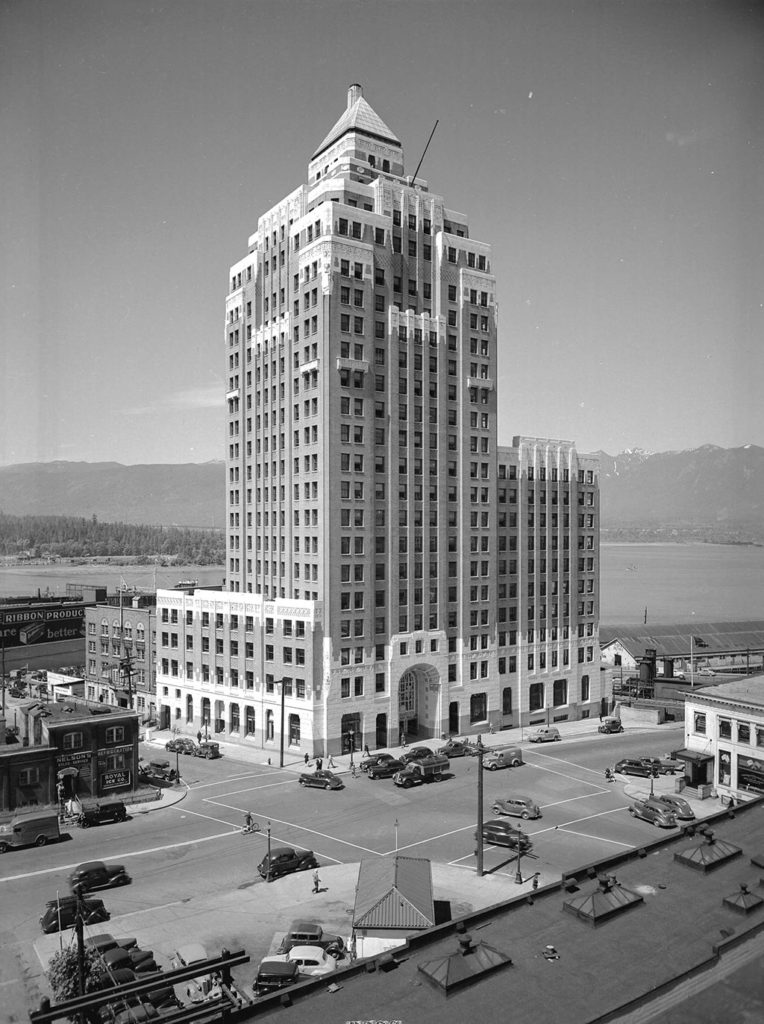 Art-deco styled twenty-two-floor building of brick and concrete with a large, arched entrance and rising up to a small pyramid at the top.