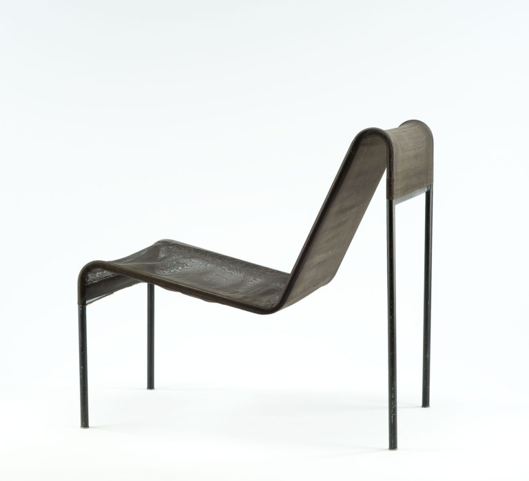 Black chair with nylon mesh upholstery stretched between the two continuous bars of the tubular-steel frame.