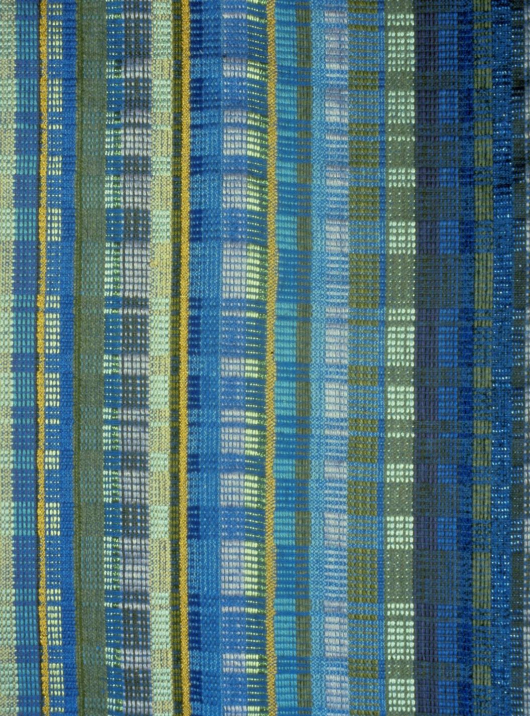 Textile with block pattern in various shades of blue, green, grey, and yellow.