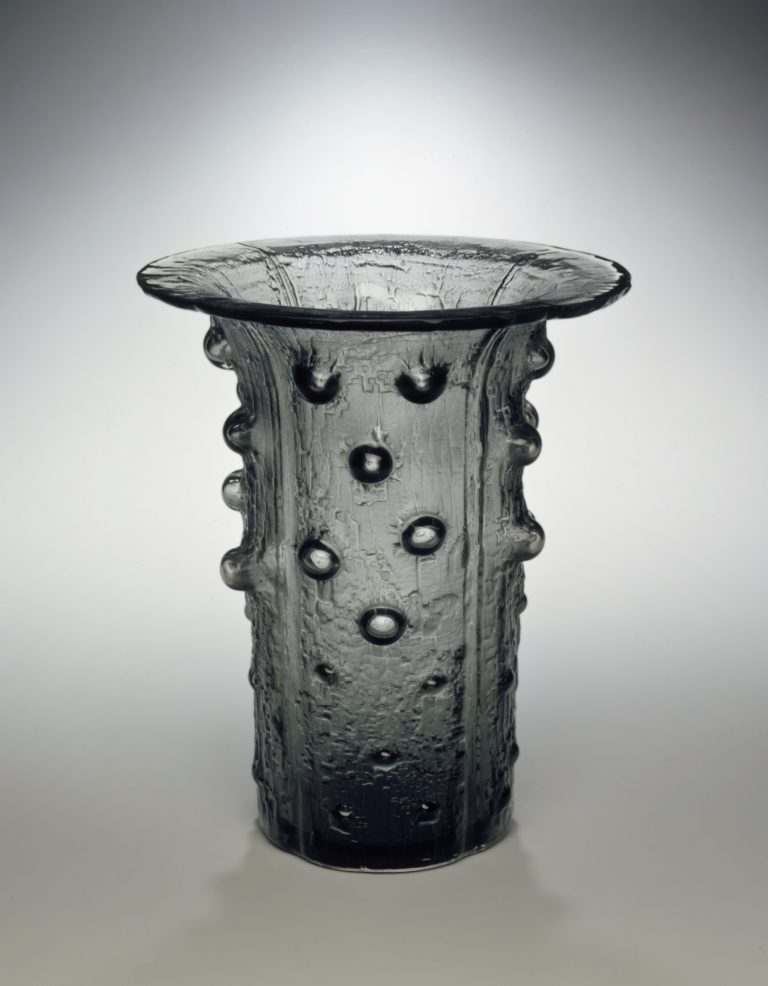 Cylindrical vase of textured glass with bumps and wide flared opening at the top.
