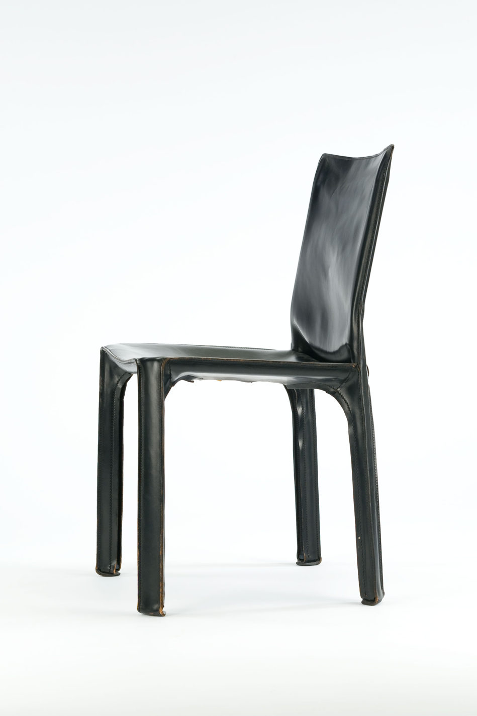 Chaise simple à quatre pattes entièrement drapée de cuir noir.