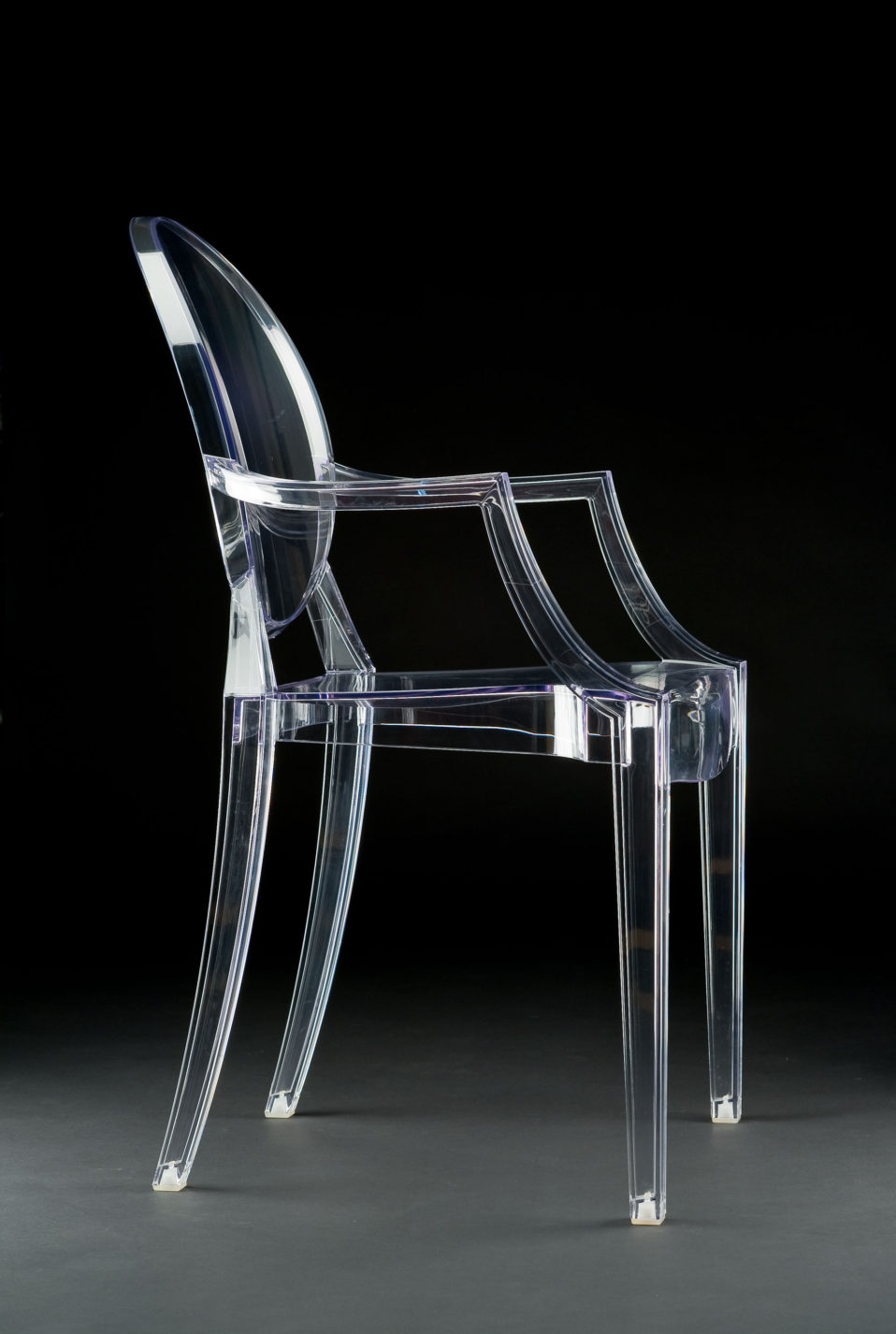 Fauteuil de plastique transparent à dos ovale de la forme des chaises antiques.