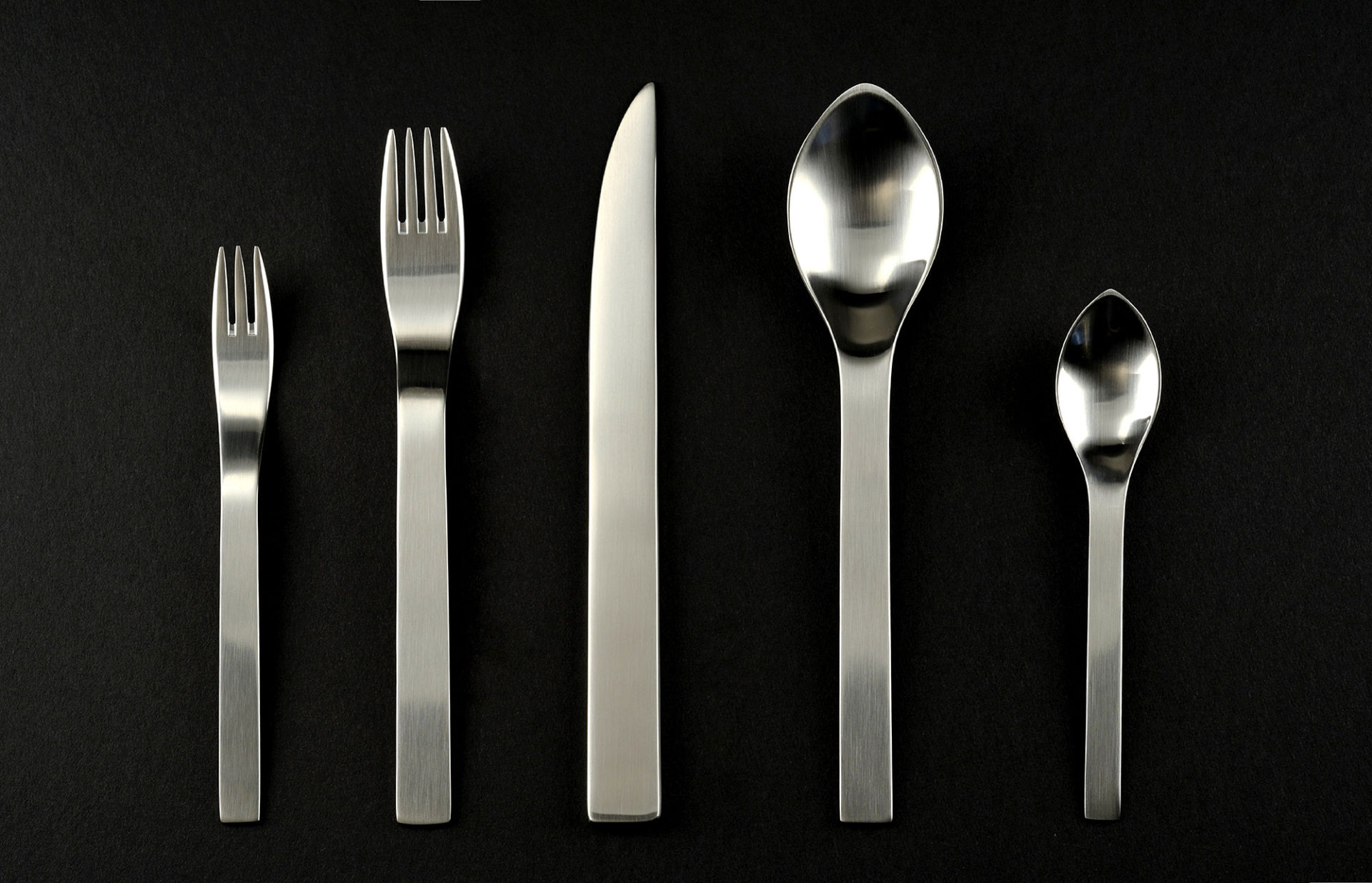 Set of steel flatware. Small and large forks, a knife, and small and large spoons.