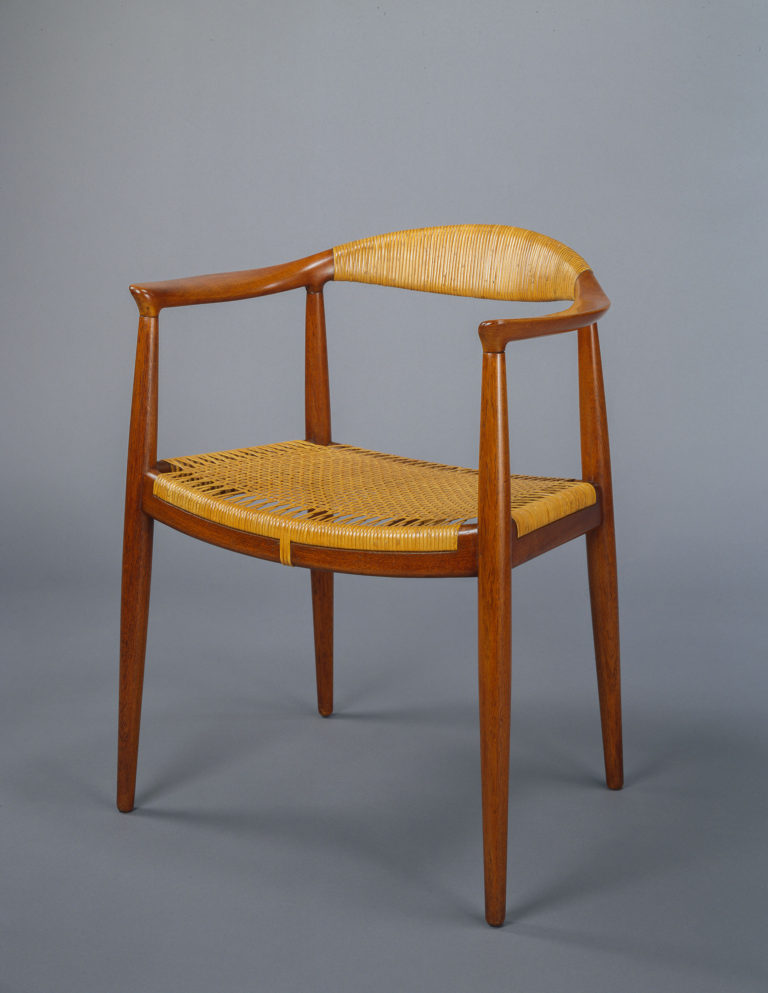 Wooden armchair with slender legs, a wrapped cane back, and a woven cane seat.