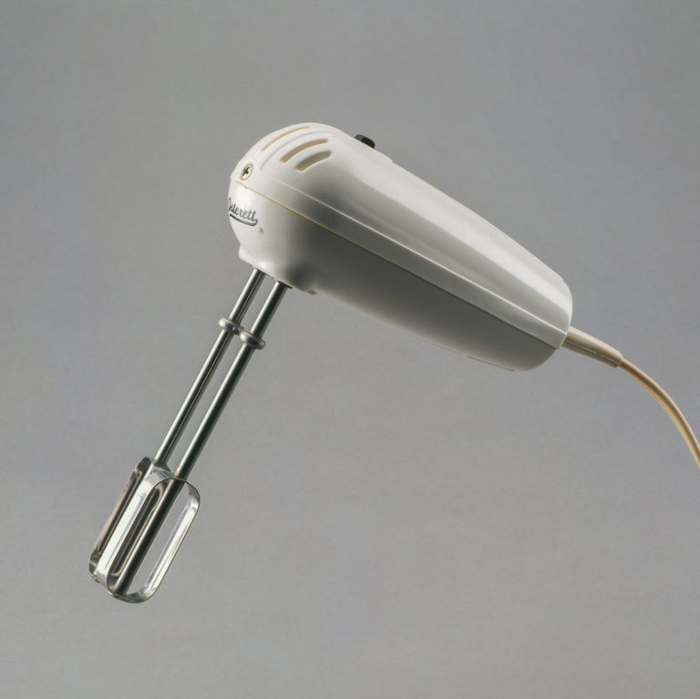 Hand mixer with peg-shaped white plastic body and two metal beaters.