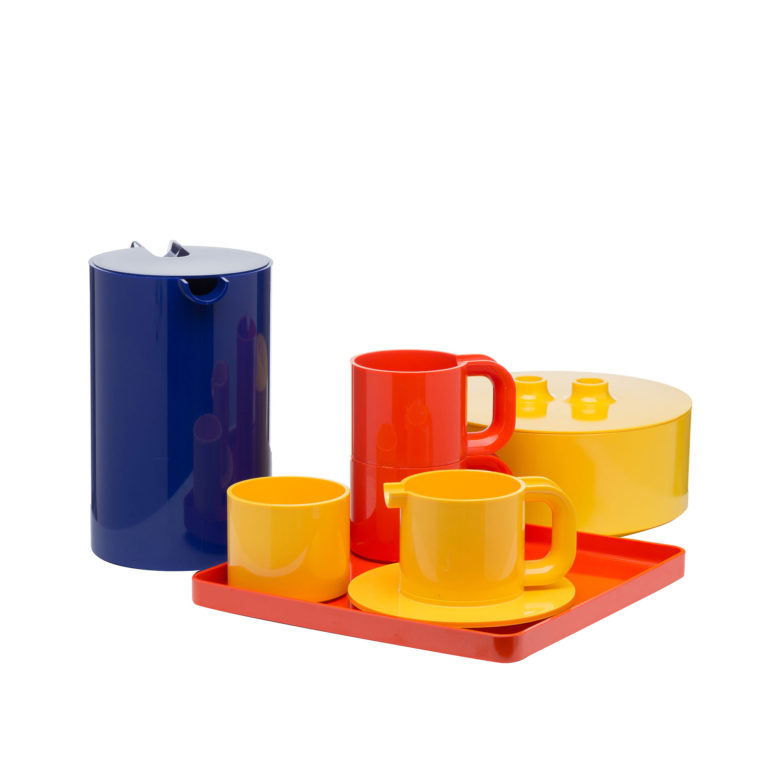 Set of brightly colored plastic dishes.  Cylindrical vessels with small circular plates and a rectangular tray in blue, orange, and yellow.
