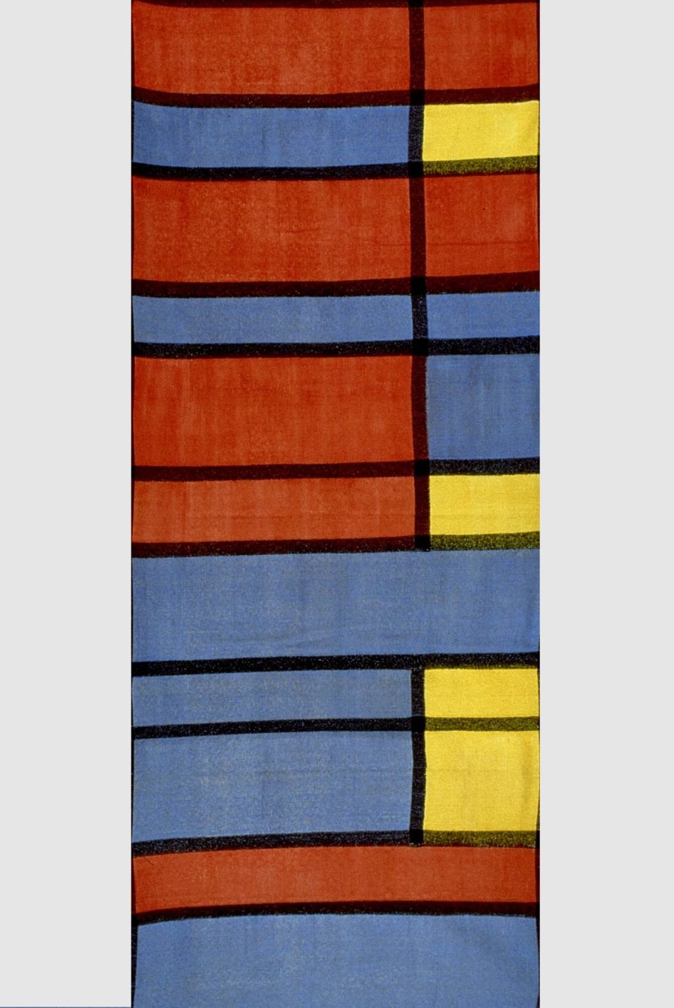Textile with rectangles of red, blue, and yellow separated by black lines.