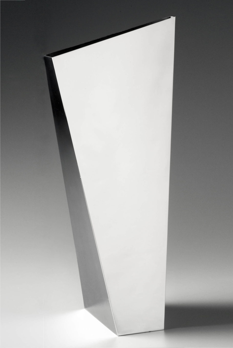 Vase de métal angulaire; chaque côté forme un trapèze de taille différente.